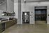 Modern apartment lobby featuring sleek storage solutions, bright lighting, and a welcoming coffee station.