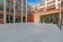 Modern apartment exterior with sleek design, expansive windows, and inviting entrance surrounded by plant decor.