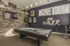 Two-Bedroom Apartments in Vineyard, UT - Concord at Geneva - Game Room With Pool Table, Wall Mounted Television, Bar Seating, And Sports Themed Decor Under Pendant Lights.