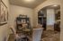 dining room with 4 person circular dining table, dishware credenza and archway leading to kitchen