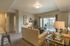 Vineyard, UT, Apartments With In-Unit Washer and Dryer - Concord at Geneva - Living Room With Plush Sofa, Accent Chairs, Glass Coffee Table, And Sliding Glass Doors Leading To Private Patio.