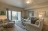 Apartments Near University Mall in Vineyard, UT - Concord at Geneva - Living Room with Carpet Flooring, Couch, 2-Seater Sofa, Armchair, Glass-Top Coffee Table, and Sliding Glass Door with Access to Patio