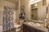 Master bathroom with sink vanity, toilet, tub/shower combo, and walk-in closet entrance