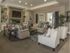 Clubhouse waiting room with 2 couches, 2 chairs, coffee table, flat screen television, and fireplace
