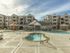 Concord pool area showing double infinity jacuzzi in front of pool and splash-pad with surrounding cabanas and activity center.