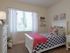 Second bedroom with twin bed, nightstand, dresser, and large window