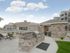 Kansas City, Missouri, Apartments with In-Unit Washer and Dryer - Steeplechase - Outdoor Barbecue Area Featuring a Stone-Clad Kitchen with Built-in Stainless Steel Grill and Granite Countertop, Mat, Landscaping, Sun Loungers, Overlooking the Cabanas, Swimming Pool, and Clubhouse.