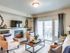 Nampa, ID Luxury Apartments for Rent - The Station at Gateway - Living Room with Fireplace, Couch, Armchairs, Coffee Table, and Sliding Glass Door with Access to Patio.