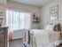 Second bedroom with twin bed, side table, dresser, and large window