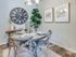 Apartments in Boise, ID, With In-Unit Washer and Dryer - Kensington - Styled Dining Area With Round Table Set For Four, Rustic Wall Clock, Framed Art, and Modern Pendant Light.