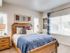 4-Bedroom Apartments in Boise, ID - Kensington - Master Bedroom with 9-Foot Ceiling, Carpet Flooring, Queen Size Bed, Nightstands with Lamps and Home Decor, Wall Arts, and Large Windows with Blinds and Curtains.