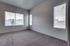 Master bedroom with large window and two small side windows.