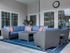 Sitting area outside of clubhouse with 1 L-couch and 2 chairs