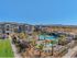 1-Bedroom Apartments in St. George, UT - Grayhawk at River's Edge - Aerial View of The Luxurious Pool Area Surrounded By Palm Trees and Modern Housing