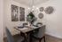 Dog-Friendly Apartments in Kearns, UT - Carrington Square - Dining Room with Wood-Style Flooring, Modern-Style Chandelier, 4-Seater Dining Set, and Wall Decors.