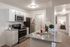 Kearns, UT Pet-Friendly Apartments - Carrington Square - Kitchen with Modern Custom White Cabinetry, Granite Countertops, White Subway Tile Backsplash, Wood-Style Flooring, Stainless Steel Appliances, and a Hallway Leading to Bedroom.