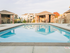 Pool in front of 2 pool cabanas and seating area