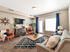 Living room with couch, coffee table, flat screen television, 2 chairs, and console table