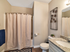 Second bathroom with sink vanity, toilet, tub/shower combo, and walk-in closet entrance