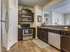 Dog-Friendly Apartments in Meridian, ID - Regency at River Valley - Kitchen with Wood-Style Flooring, Granite Countertops, Tile Backsplash, Customized Cabinetry, Corner Pantry, Stainless Steel Appliances Including Refrigerator, Oven, Built-in Microwave, and Dishwasher, Rug, and Eat-In Kitchen.