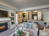 Meridian, ID, Pet-Friendly Apartments - Regency at River Valley - Living Room with Carpet Flooring, Built-in Entertainment Wall and Shelves, Modern Fireplace, Couch, Glass Coffee Table, Home Decor, and View of the Kitchen and Dining Area.