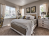 3-Bedroom Apartments in Meridian, ID - The Regency at River Valley - Sunlit Bedroom With Upholstered Bed, Layered Bedding, Framed Floral Art, Dual Windows, And Plush Carpet.