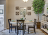 Two-Bedroom Apartments in Meridian, ID - The Regency at River Valley - Bright Dining Area With Round Table, Mixed Back Chairs, Floral Centerpiece, Wall Art, And Adjacent Bedroom Entry.