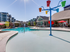 Three-Bedroom Apartments in Meridian, ID - Regency at River Valley - Large Outdoor Swimming Pool with Splash Pad and Colorful Tipping Buckets, Surrounded by Umbrella-Shaded Loungers and Apartments.
