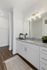 Dog-Friendly Apartments in Twin Falls, ID - Rivercrest - Bright Bathroom Vanity With Speckled Countertop, Large Mirror, Glass Shade Lighting, White Cabinetry, And Access To Spacious Closet.