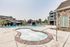 One-Bedroom Luxury Apartments in Nampa, ID - The Station Apartments at Gateway -Swimming Pool With Hot Tub, Lounge Chairs, Poolside Seating, And Apartment Buildings.