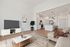 Dog-Friendly Luxury Apartments in Nampa, ID - The Station Apartments at Gateway -Living Room With Sofa, Coffee Table, Television, Island Seating, and Pendant Lights.