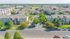 Aerial view of a beautifully landscaped apartment complex with multiple modern buildings, lush greenery, and tree-lined streets creating a welcoming residential environment.