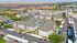 Aerial view of a modern apartment community with multiple buildings surrounding a central pool area, featuring scenic canyon views and ample parking space.