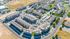 Vibrant aerial view of a modern apartment complex with lush greenery, ample parking, and well-maintained communal areas.