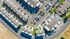 Vibrant aerial view of a modern apartment complex with sleek architecture, ample parking, and well-maintained green spaces.
