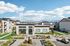 Modern apartment complex with scenic mountain views, lush landscaping, and a welcoming office entrance.
