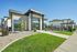 Modern fitness center with sleek architecture and lush landscaping under a clear blue sky, perfect for an active lifestyle.
