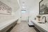 Elegant and modern laundry room with sleek countertops, washing machines, and decorative artwork, perfect for efficient living.