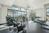 Bright and modern gym with state-of-the-art exercise equipment, featuring large windows offering serene outdoor views.