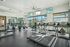 Bright and modern gym featuring state-of-the-art treadmills, exercise bikes, and expansive windows with natural light.