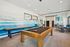 Chic recreational room with a pool table, stylish artwork, and comfortable seating, perfect for socializing and entertainment.