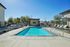 Luxurious outdoor swimming pool with sun loungers and shaded seating, perfect for relaxation and leisure.
