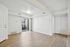 Bright and spacious living area with elegant wood flooring, modern light fixture, and access to a private balcony.