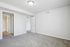Bright and spacious bedroom with soft carpeting, modern light fixture, and convenient access to an adjacent bathroom.