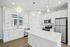 Bright, modern kitchen with sleek white cabinetry, stainless steel appliances, and spacious center island, perfect for entertaining.