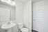 Bright and modern bathroom with sleek pedestal sink and efficient storage space.