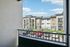 Charming apartment balcony view showcasing modern architecture, vibrant landscaping, and convenient parking.