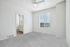 Bright and spacious bedroom with plush carpet, large window, and access to a modern en-suite bathroom.