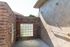 Inviting outdoor shower with elegant brick and tile walls, featuring sleek chrome fixtures and natural light from glass block windows.