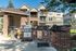 Charming outdoor communal space featuring stylish brick BBQ grills and cozy seating, perfect for gatherings in a serene residential setting.